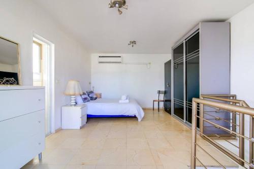 - une chambre blanche avec un lit et une commode dans l'établissement Duplex 2BR in Ben Yehuda by Holiday-rentals, à Tel Aviv