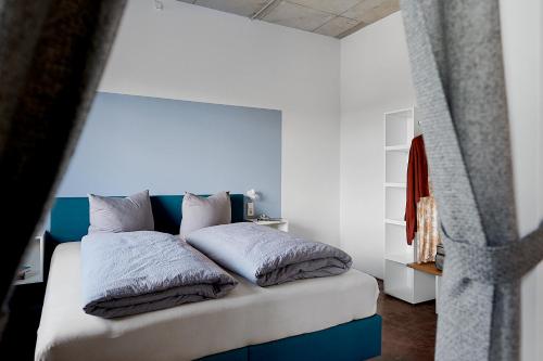 a bedroom with a bed with blue and white pillows at Kulturfabrik Schönbach in Schönbach