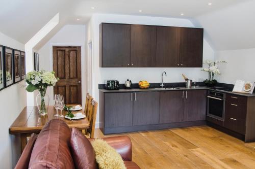 eine Küche mit einem Sofa und einem Tisch in einem Zimmer in der Unterkunft The Loft at Hewletts Farm - Stunning Apartment on The Cotswold Way Close to Cheltenham in Cheltenham
