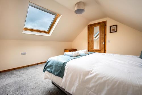 a bedroom with a large bed and a window at Scotia House -3 bed house in Larkhall with private driveway in Larkhall