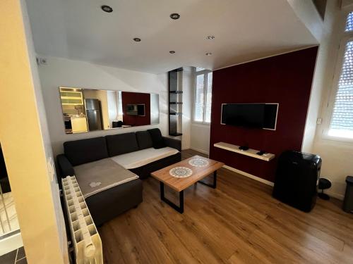 un salon avec un canapé et une table dans l'établissement NIMES Superbe appartement duplex climatisée, à Nîmes