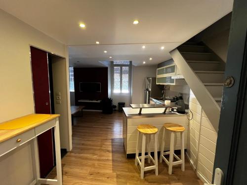 a kitchen with a sink and a counter with stools at NIMES Superbe appartement duplex climatisée in Nîmes