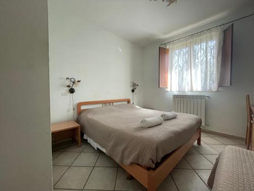 1 dormitorio con 1 cama con 2 toallas en Agriturismo Le Due Arcate, en San Massimo