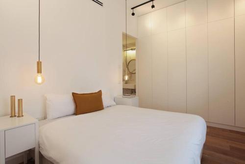 um quarto com uma cama branca e um armário branco em Modern 1BR in Dizengoff by Holiday-rentals em Tel Aviv