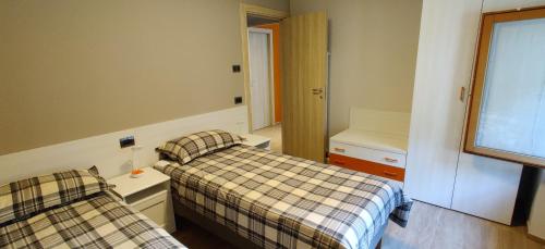 a bedroom with two beds and a window at Casa Vacanza Beltrami in Baceno