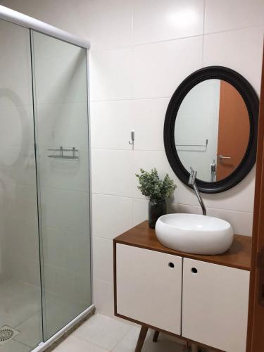a bathroom with a sink and a mirror at Itacolomi Home Club Apto 404 T1 in Penha