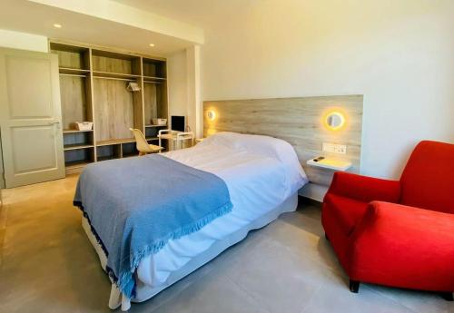 1 dormitorio con 1 cama y 1 silla roja en Villa La Roca en Torreguadiaro