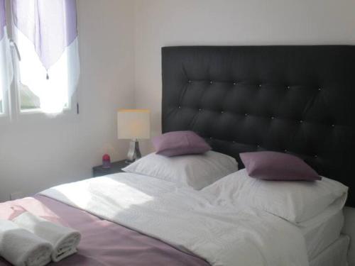 une chambre avec un grand lit avec deux oreillers dans l'établissement La p'tite maison du Chateau, à Éclassan