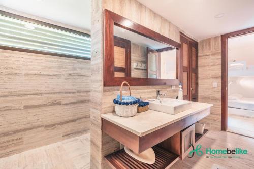 ein Bad mit einem Waschbecken und einem Spiegel in der Unterkunft A familys best friend enjoy this One BR Apartment at Portillo in Las Terrenas