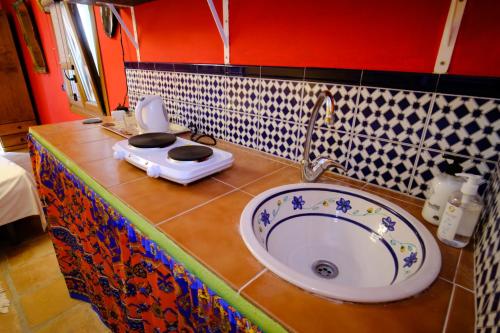 La salle de bains est pourvue d'un lavabo et de toilettes sur un comptoir. dans l'établissement The Studio Under The Wall, a colourful, small and unique one bedroom studio in Comares, à Comares