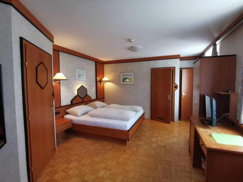 a bedroom with a bed and a desk and a television at Landrasthaus Maria Bild in Maria Bild