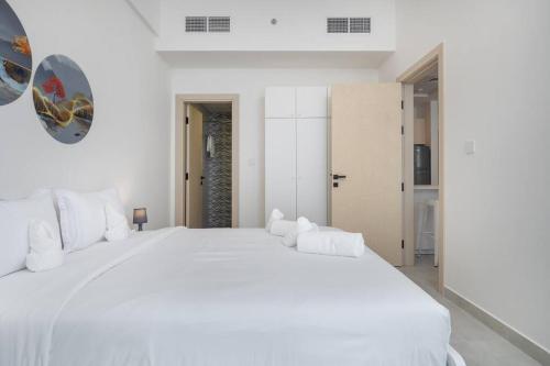a white bedroom with a large white bed at Restful apartment with private terrace by the pool in Dubai