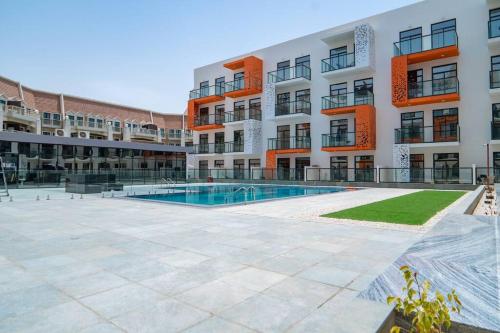 an apartment complex with a swimming pool in front of a building at Restful apartment with private terrace by the pool in Dubai