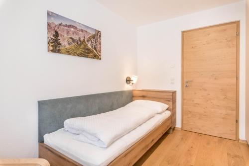 1 dormitorio con 1 cama con cabecero de madera en Residence Diana Apartment 401, en Terento