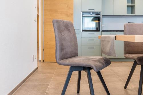 a kitchen with two chairs and a wooden table at Residence Diana Apartment 402 in Terento