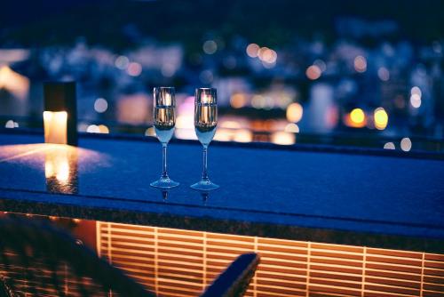 three wine glasses sitting on top of a ledge at Sora Niwa Terrace Kyoto in Kyoto