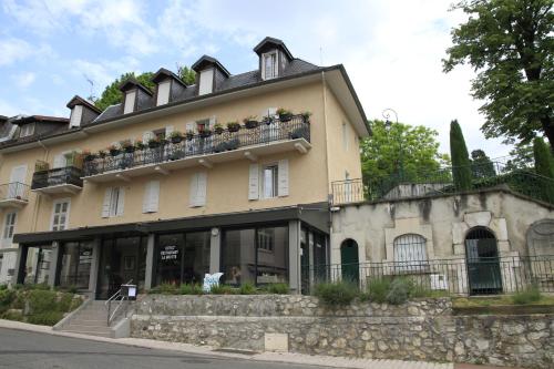 Un grand bâtiment avec un balcon est à votre disposition. dans l'établissement Hôtel de la Grotte, à Aix-les-Bains