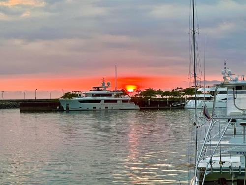 a group of boats docked in a marina with the sunset at Cabinas Chazu #2 in Quepos