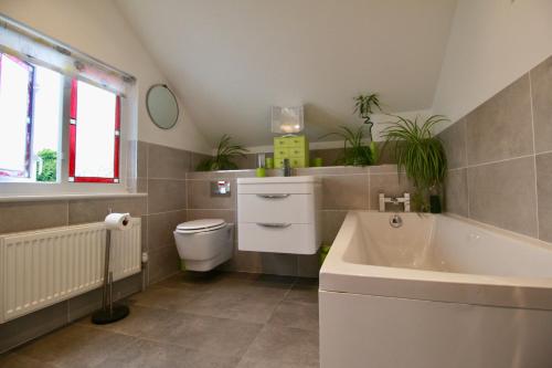 a bathroom with a sink and a toilet and a tub at Blachington Cottage, Stunning and Central By Air Premier in Seaford