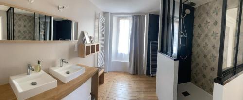 a bathroom with two sinks and a mirror at Appartement cosy face à la Mayenne in Laval