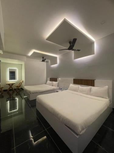 um quarto com 2 camas e uma ventoinha de tecto em Villa Bordeaux em Pondicherry