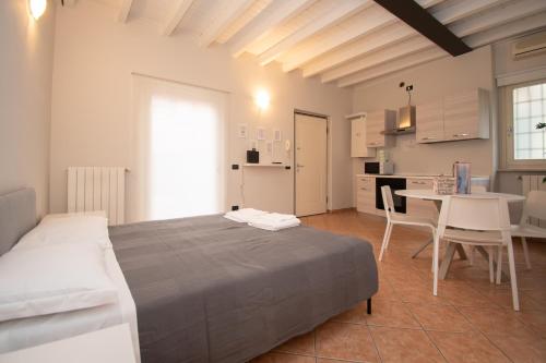 ein Schlafzimmer mit einem Bett und einem Tisch sowie eine Küche in der Unterkunft Corte Poliambulanza - F&L Apartment in Brescia