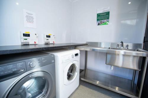 a kitchen with a washing machine and a sink at Fairwood Lakes Holiday Park- Fishing Breaks - Woodland Huts in North Bradley