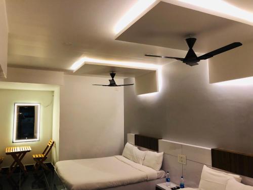 ポンディシェリにあるVilla Bordeauxの天井ファン2台とソファが備わる客室です。