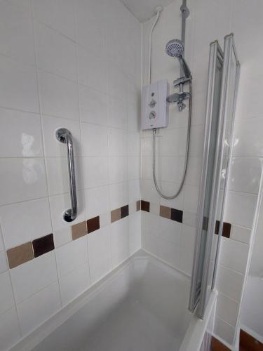 a bathroom with a bath tub with a shower at Private apartment, parking, sea and country views in Lyme Regis