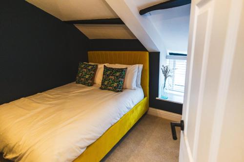 a bedroom with a bed with a yellow and black wall at Cathys Cottage, Sun Trap Patio, Modern 3 Bed, Central, Parking in Crewkerne