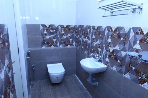 La salle de bains est pourvue de toilettes et d'un lavabo. dans l'établissement The green pride resort, à Yelagiri