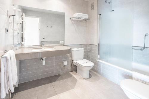 a bathroom with a toilet and a sink and a shower at Can Fisa Hotel & Apartments in Corbera de Llobregat