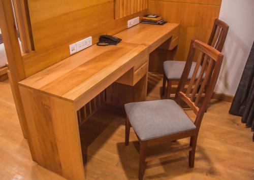 a wooden desk with two chairs in a room at Pelyang Boutique in Thimphu