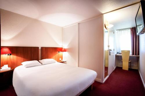 una habitación de hotel con una gran cama blanca y una ventana en Hotel inn design Macon Sancé ex kyriad, en Mâcon