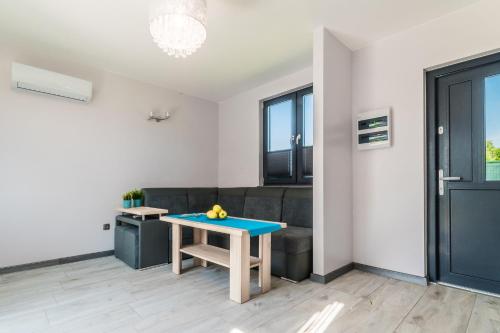 a living room with a table and a couch at Hygge Domki in Junoszyno