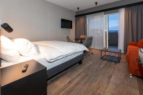 een hotelkamer met een bed en een woonkamer bij Hotel Halond in Akureyri