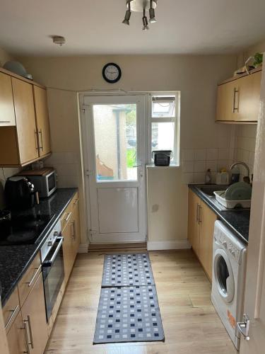 a kitchen with a door with a rug on the floor at Shared House in Chakeshill Drive in Bristol
