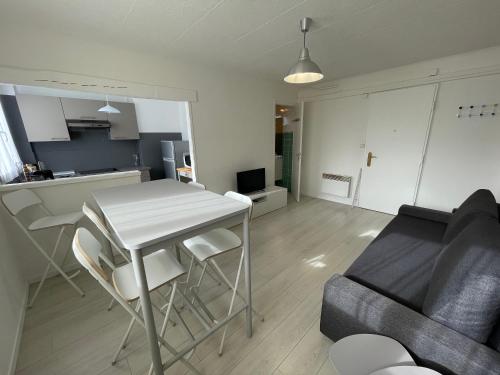 eine Küche und ein Wohnzimmer mit einem Tisch und einem Sofa in der Unterkunft Charmant Appart Stade Vélodrome/Métro Centre Ville in Marseille