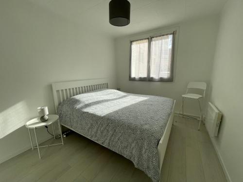 a white bedroom with a bed and two chairs at Charmant Appart Stade Vélodrome/Métro Centre Ville in Marseille