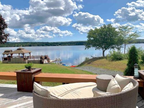 a patio with a table and chairs and a view of a lake at The Cedar at Mira Riverfront Getaway in Marion Bridge