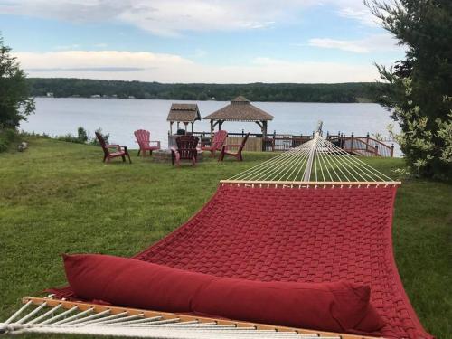 a hammock on the grass next to a body of water at The Cedar at Mira Riverfront Getaway in Marion Bridge