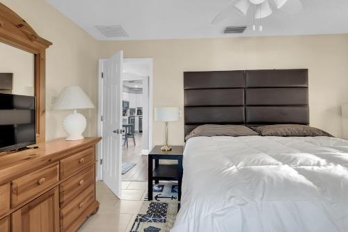 a bedroom with a large bed and a television at 232 S HARBOR DR - ISLAND BAY home in Holmes Beach
