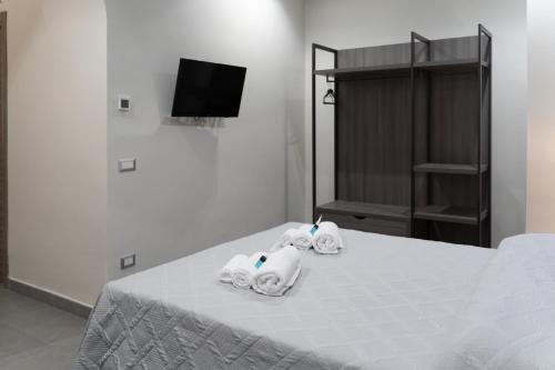 a room with a bed with three towels on it at Palazzo Marage in Torre del Greco
