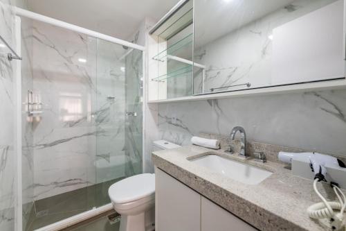 La salle de bains est pourvue d'un lavabo, d'une douche et de toilettes. dans l'établissement LIV - Apartamento 804, à Porto Alegre