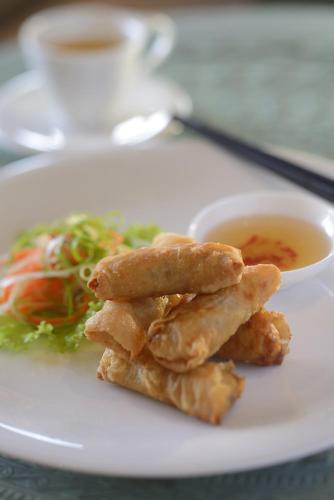 a plate of food with a salad and dipping sauce at Banyan Tree Lang Co in Lang Co