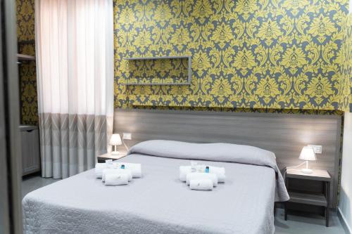 Un dormitorio con una cama blanca con dos velas. en Palazzo Marage, en Torre del Greco
