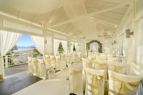 a white room with white chairs and a balcony at Banyan Tree Lang Co in Lang Co