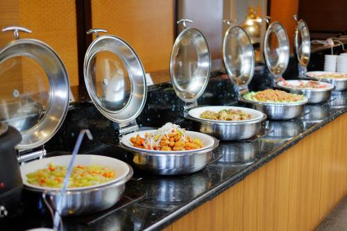 a line of bowls of food on a buffet at City Suites - Taoyuan Gateway in Dayuan