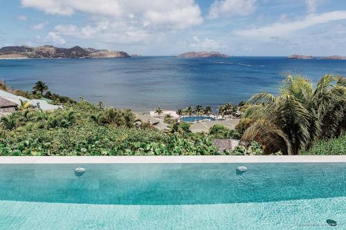 a swimming pool with a view of the ocean at Infiniti 1 BR Private Luxury Villa Breath Taking View in St Barth in Pointe Milou