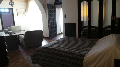 a bedroom with a bed and a couch and a chair at Targafit Hotel & Hammam in Marrakech